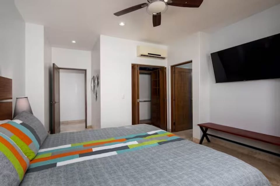 Master bedroom with walk in closet, big screen TV, ceiling fan. 