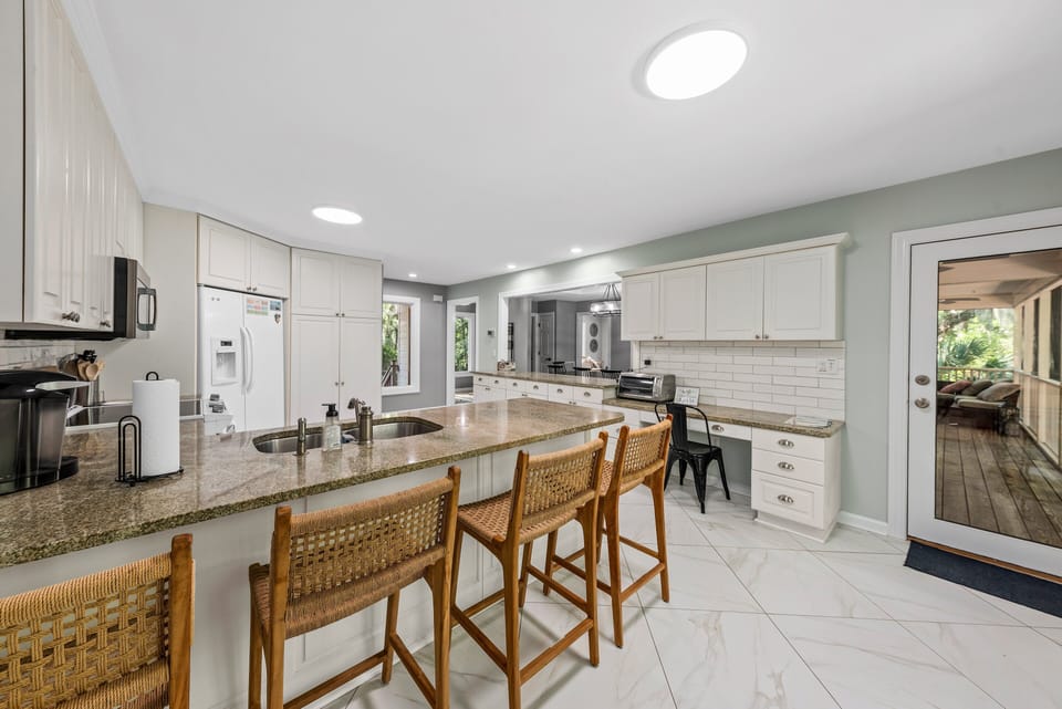 The kitchen counter seats four. The door off the kitchen leads out to the screened porch