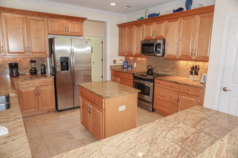Open kitchen looking into family room and rear deck