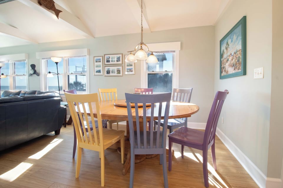 Gather around your bright dining space where colorful chairs and warm wood create the perfect setting for memorable meals together.