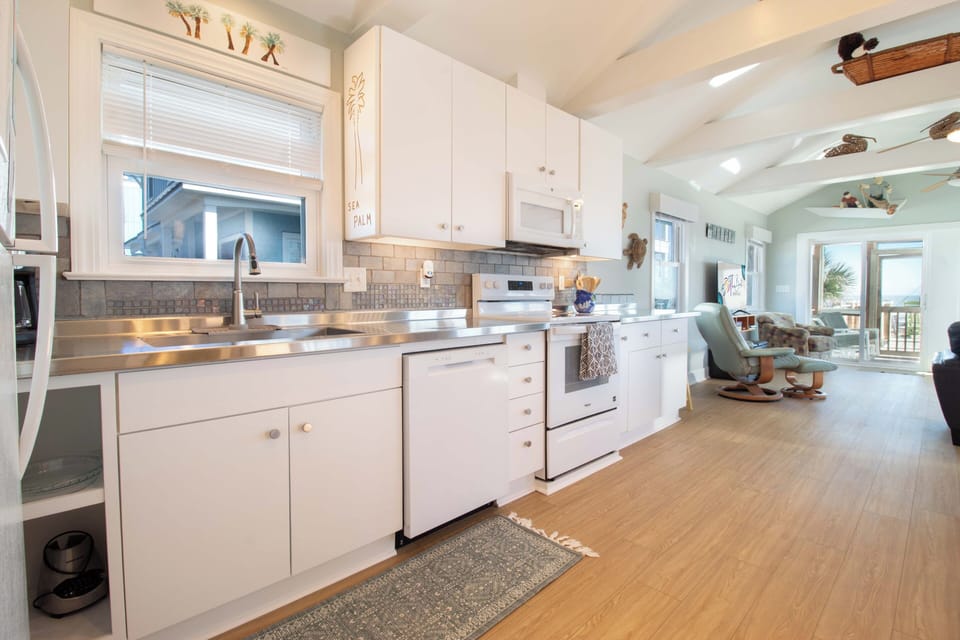 Your fully-equipped kitchen flows seamlessly into the coastal living space, perfect for preparing meals while enjoying ocean breezes.
