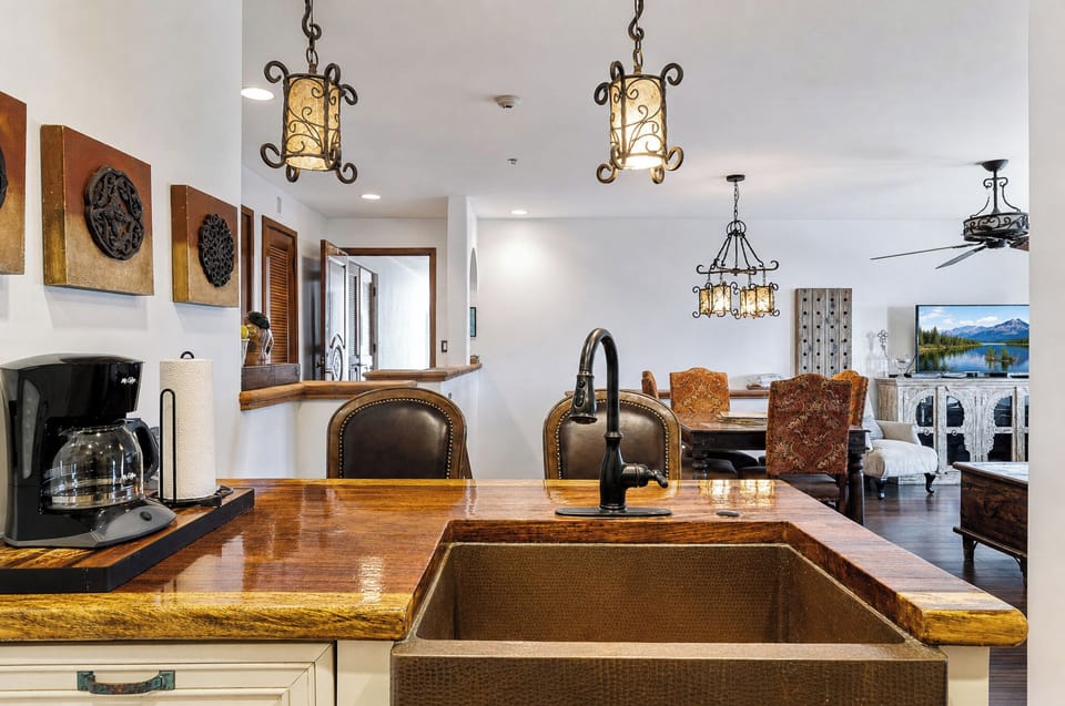 Rich wood countertops, artisan pendant lights, and an open floor plan connect you to both dining and living spaces—ideal for gathering, cooking, and unwinding together.