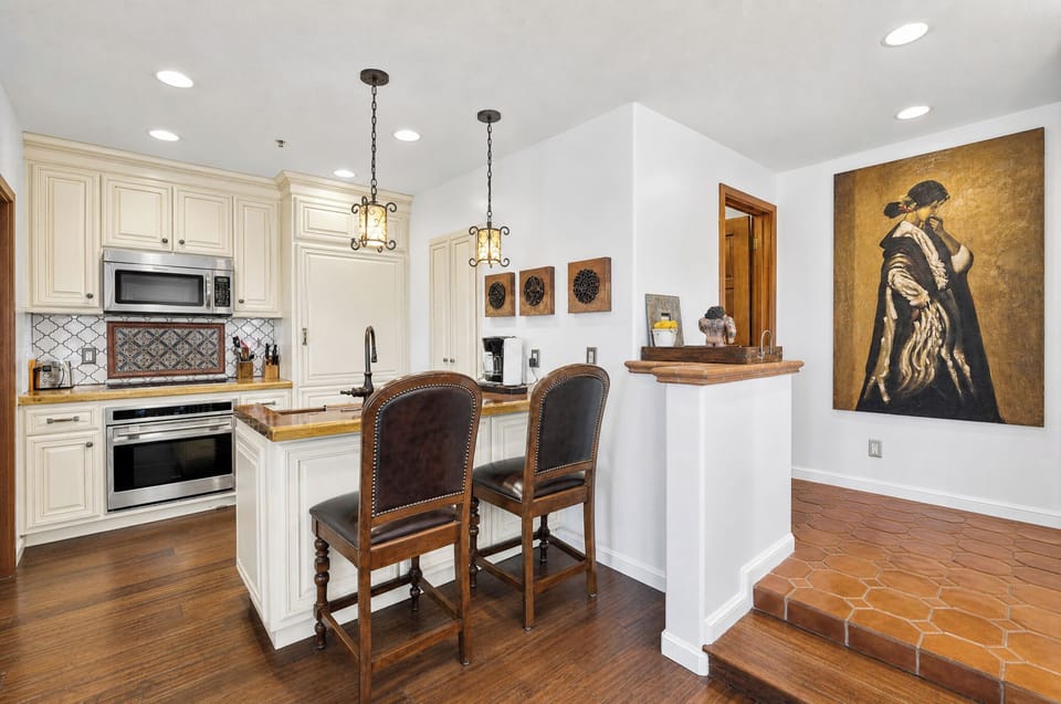 Gather around your gourmet kitchen with elegant cabinetry, modern appliances, and a cozy breakfast bar—perfectly designed for morning coffee or preparing delicious meals together.