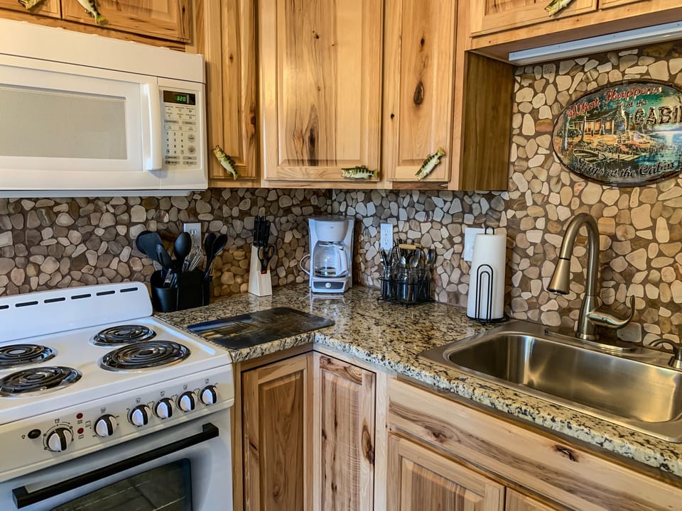 Beautiful cabinets with stone backsplash. Plus a stove/oven too.