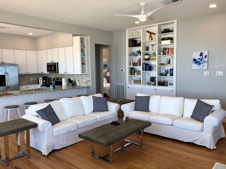 Living room and kitchen with stool seating for 5 at the counter.
