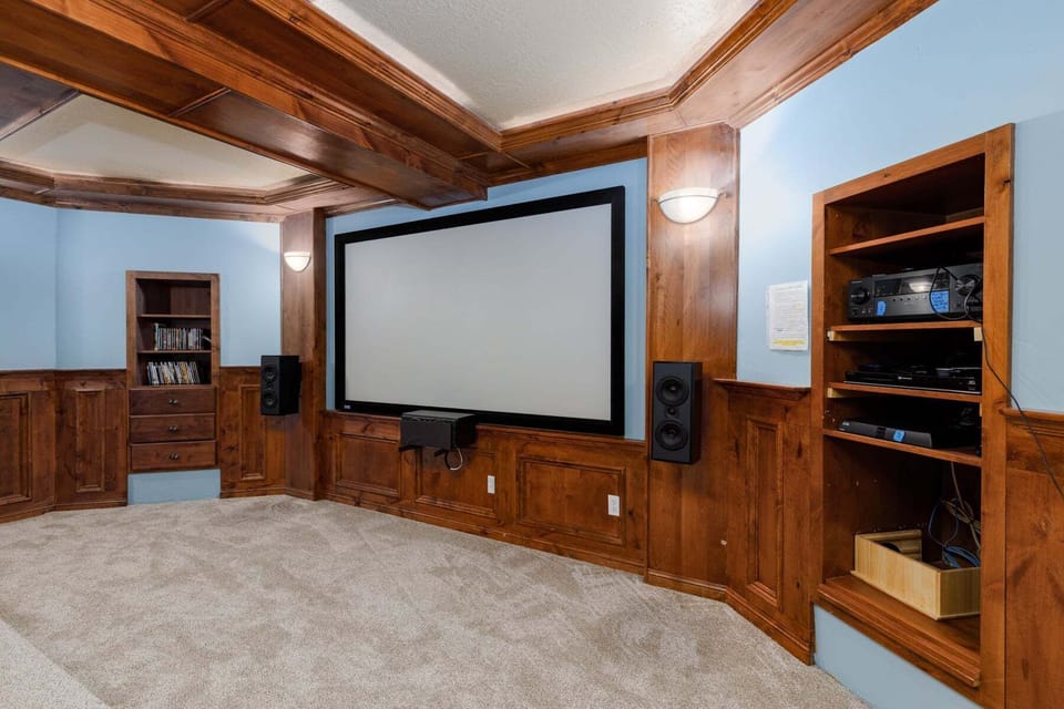 Lower level theater room featuring adjustable lighting and and a hand-finished coffered alder ceiling. Watch in several formats or even set up your own slide show using the recently updated high speed wifi.