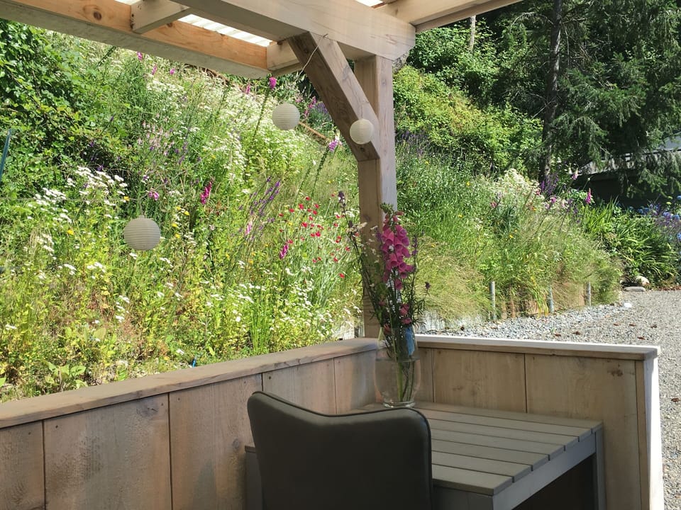 Enjoy some quiet time on the back porch at our hillside property.