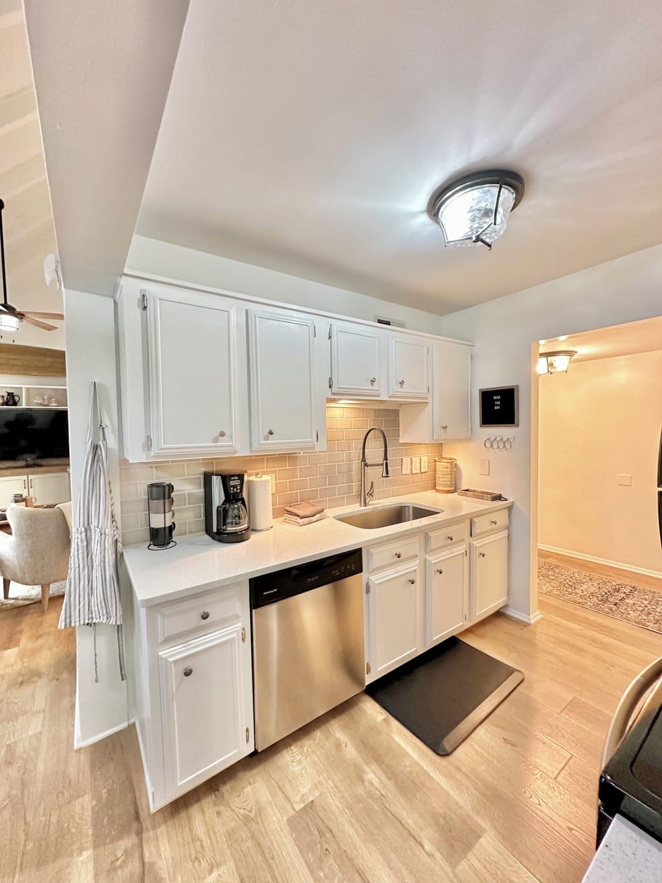 Kitchen features stainless steel appliances, coffee maker, toaster, large sink. 