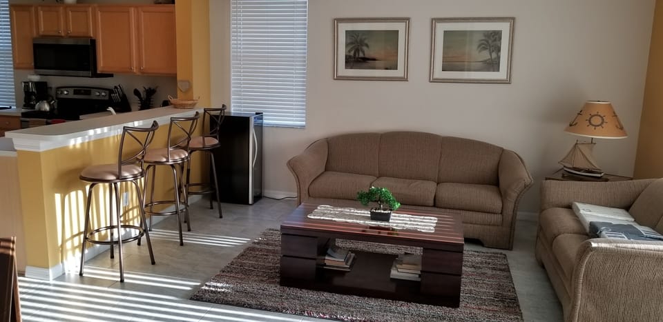 Big open family room with a wine cooler , bar stool  and a lovely center piece 