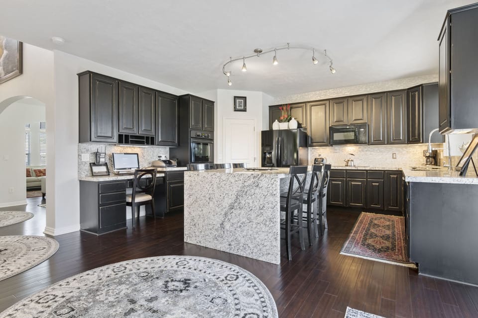 The kitchen also has a desk with a computer and printer.