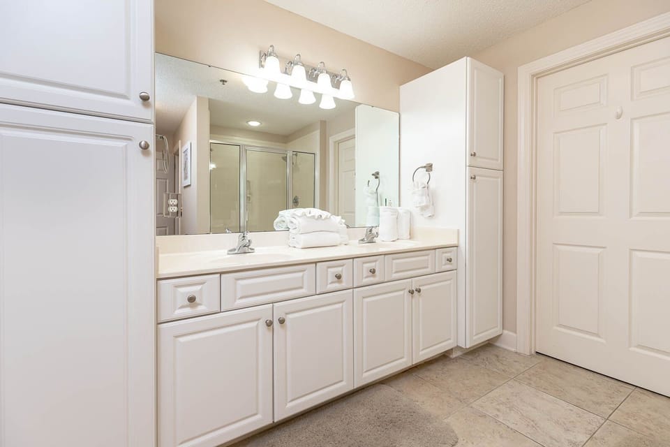 Experience this spacious master bathroom with a double vanity, ample storage, and plush towels for your comfort