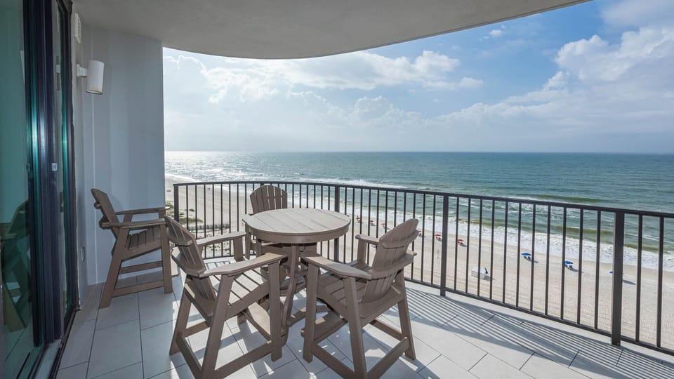 Relax at the outdoor table with seating, enjoying the view of the beach and waves just steps away