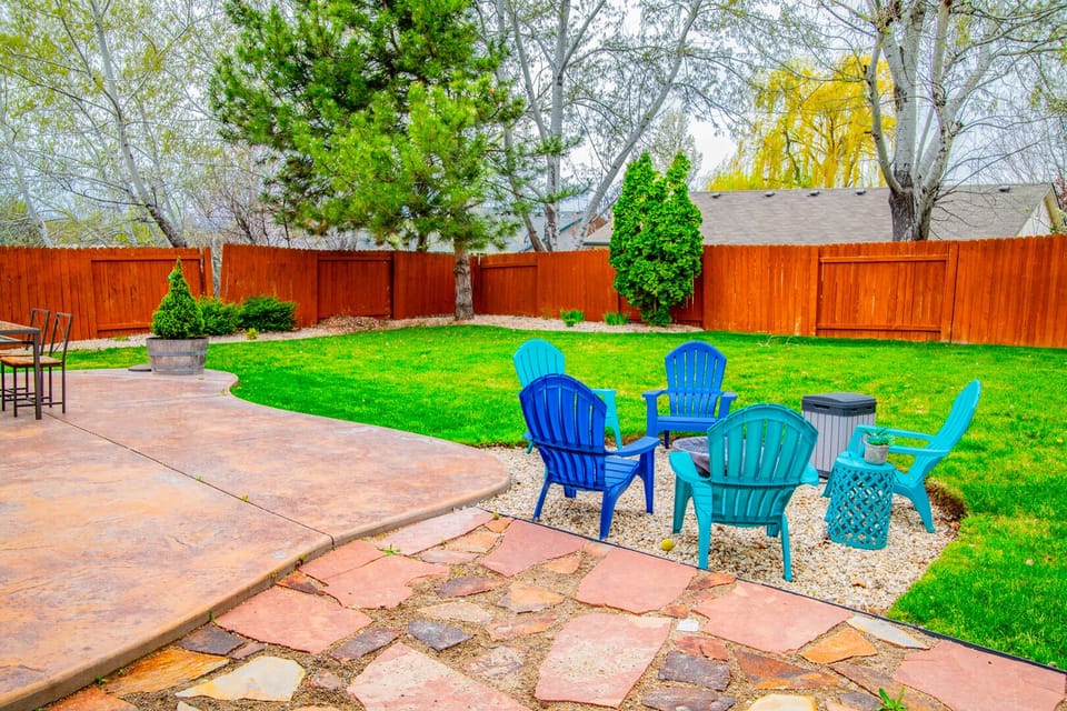 Large patio with spacious backyard and fire pit.