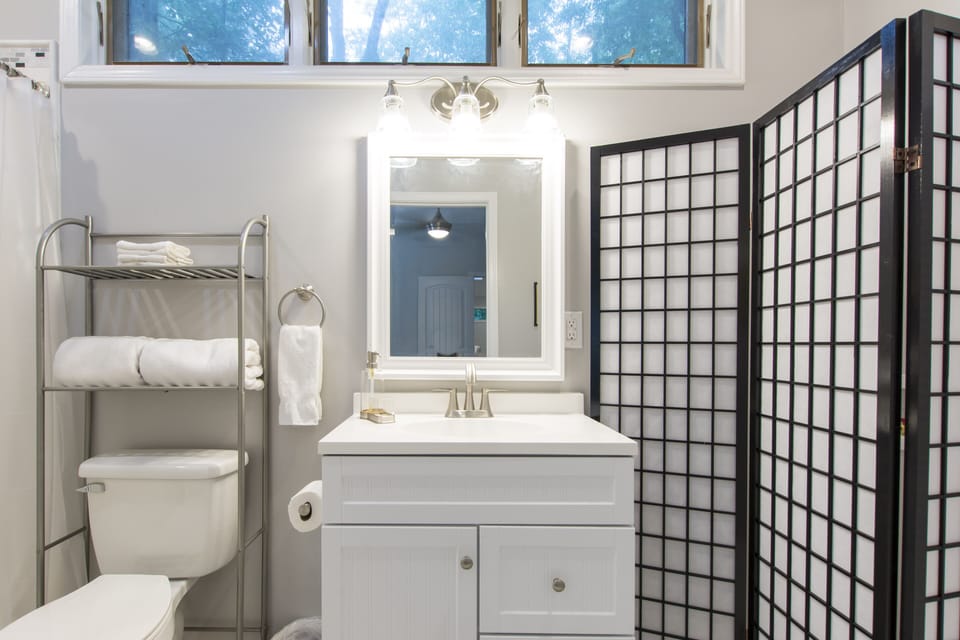 Bathroom with step in tiled shower and stack washer/dryer