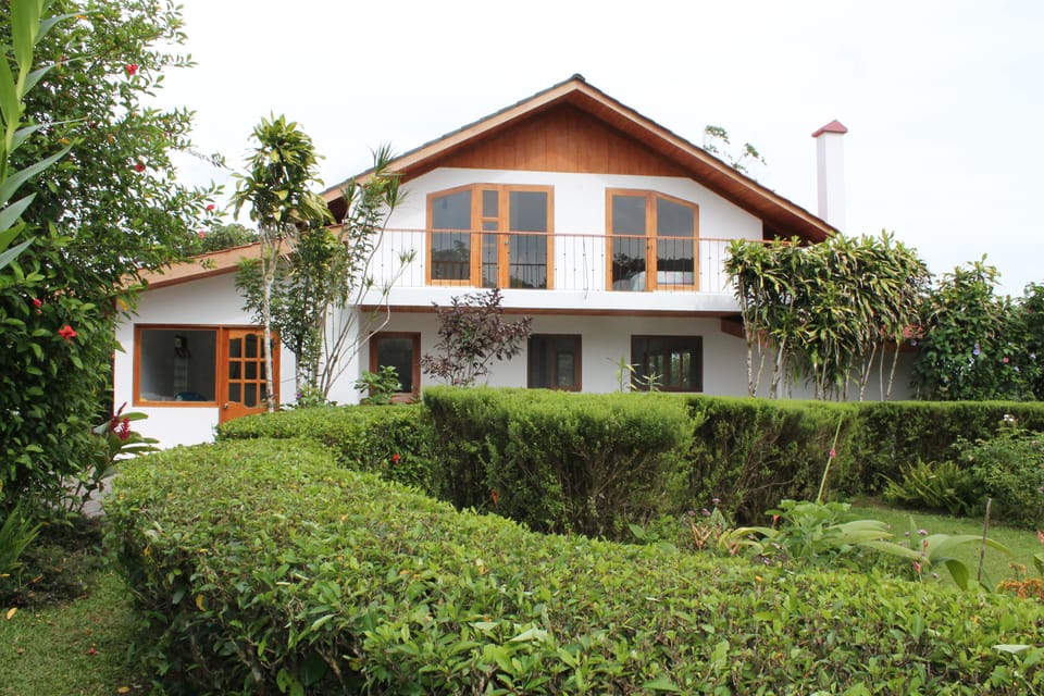 View of western side of house with private balcony overlooking gardens.