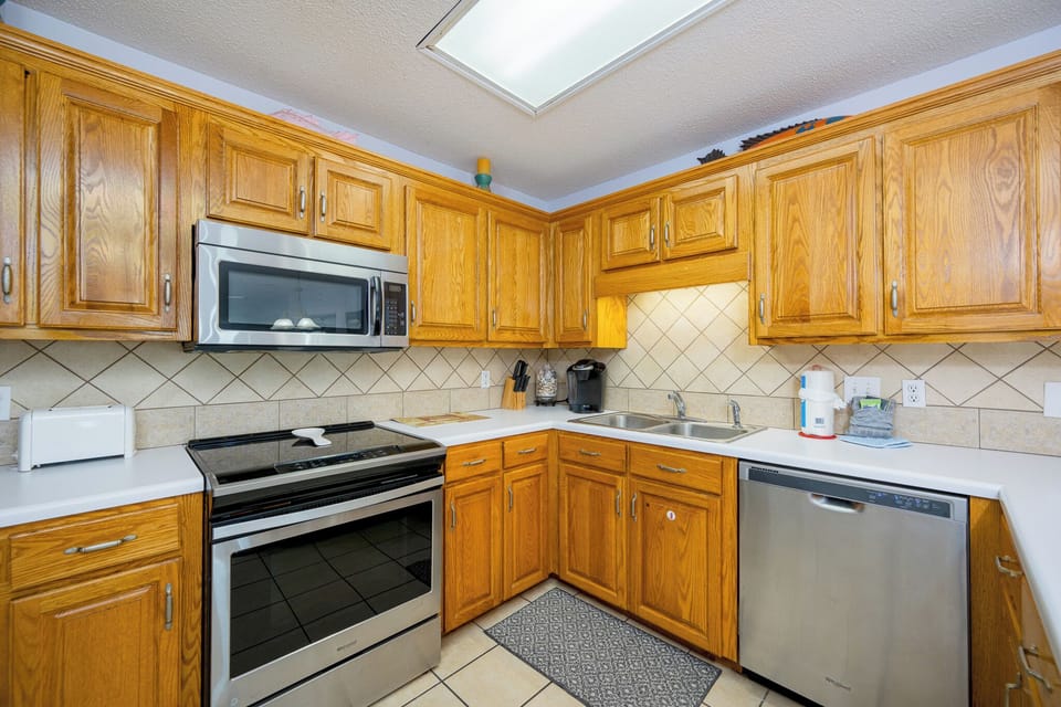 Golden oak cabinets frame your kitchen where you prepare fresh meals with stainless steel appliances