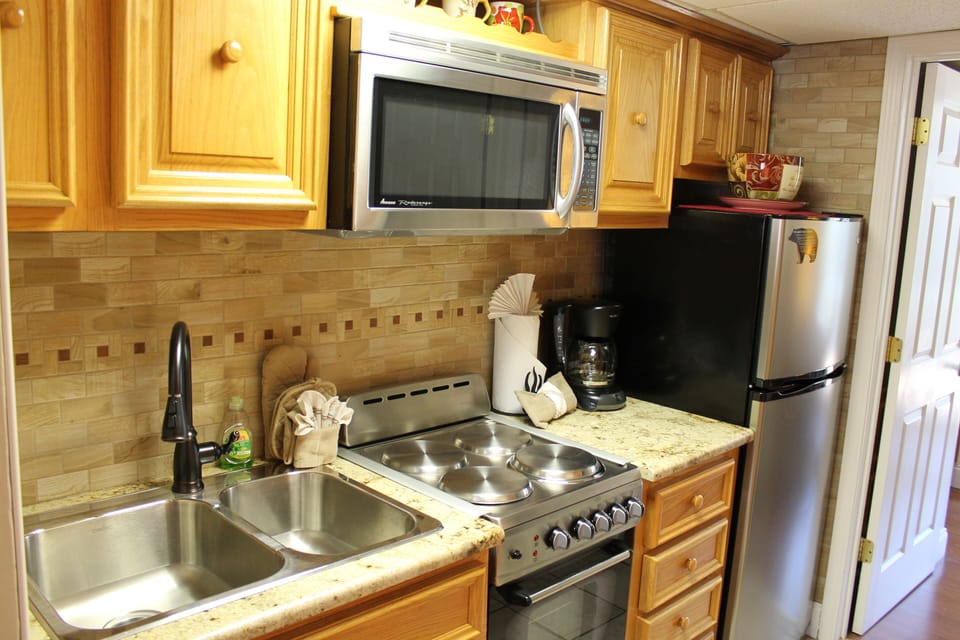 Newly renovated kitchen with granite cabinet tops and ceramic backsplash.
