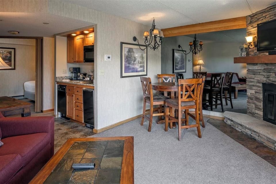 Bright open-concept living area with fireplace and dining space.