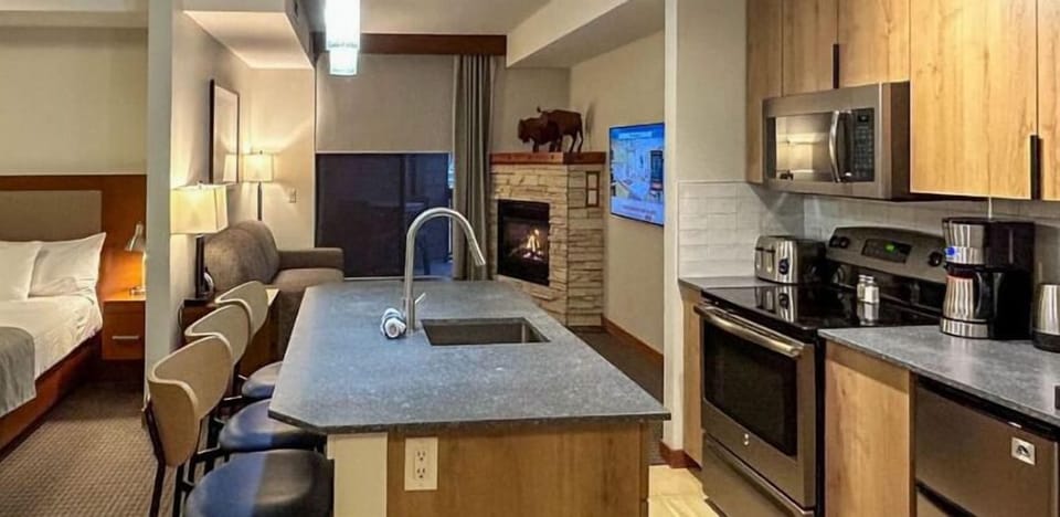 Stylish open-concept kitchen with modern appliances and a spacious island, seamlessly flowing into the cozy living and sleeping areas.