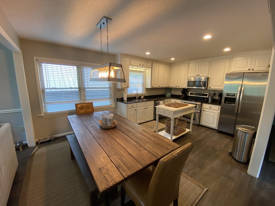 Updated kitchen with LVP flooring, new stainless steel appliances and farm table