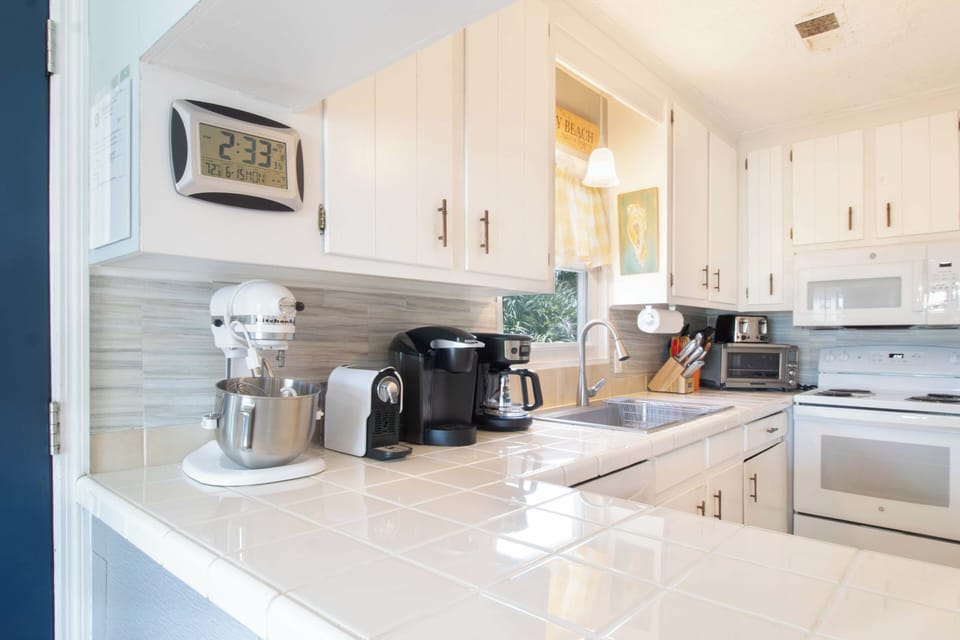Your fully-equipped kitchen features a sleek coffee maker, stand mixer, and modern appliances, ready for you to whip up homemade meals or quick breakfasts during your stay.