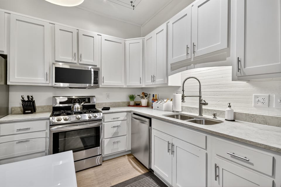 This modern kitchen features a gas stove, full cookware, sleek finishes, and a stocked coffee bar—perfect for slow mornings before exploring downtown Blue Ridge.  