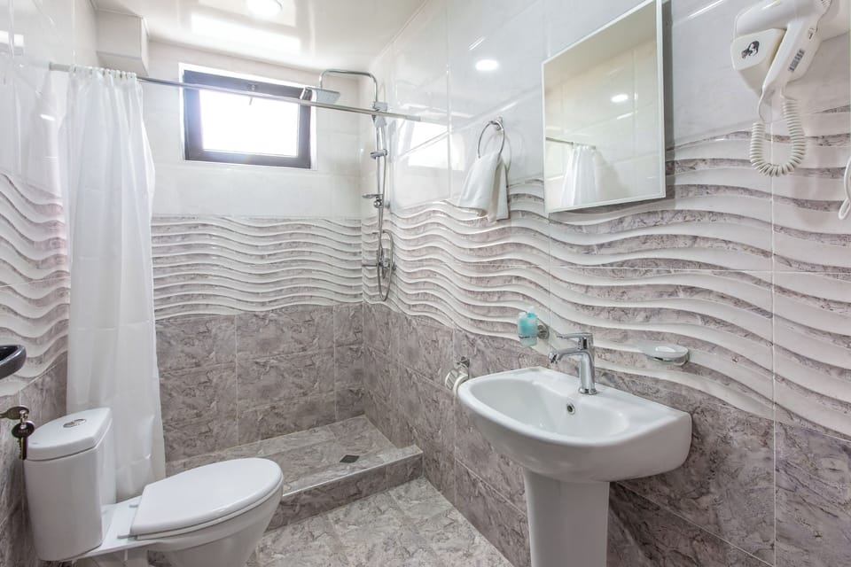 Shower, designer toiletries, hair dryer, slippers