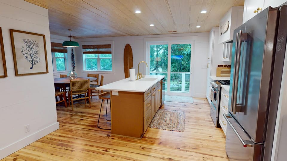 Step into your open-concept kitchen and dining area, where warm wood floors and a spacious island invite you to cook, gather, and relax. Natural light floods through glass doors leading to your private outdoor space.