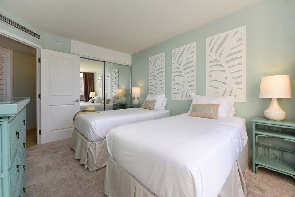 Second bedroom featuring convertible twin beds that easily transform into a king, complemented by coastal décor and gentle natural lighting