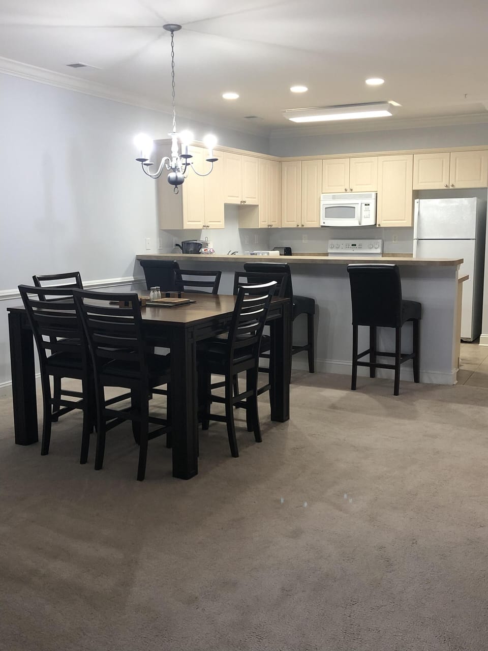 Tall dining rm table with kitchen in the background 