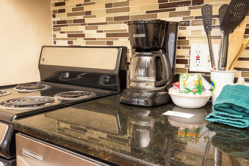 Your fully equipped kitchen features granite counters, electric stove, and coffee maker for cooking delicious meals during your stay.