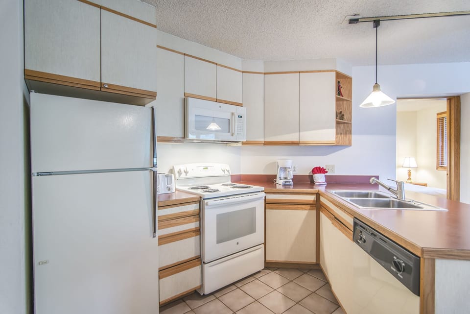 Kitchen - Full size fridge, stove, and dishwasher, double sinks, and large counter space.