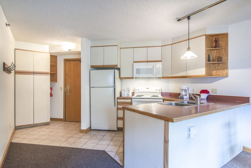 Kitchen/Entry - Coat rack, coat closet, and open kitchen area.