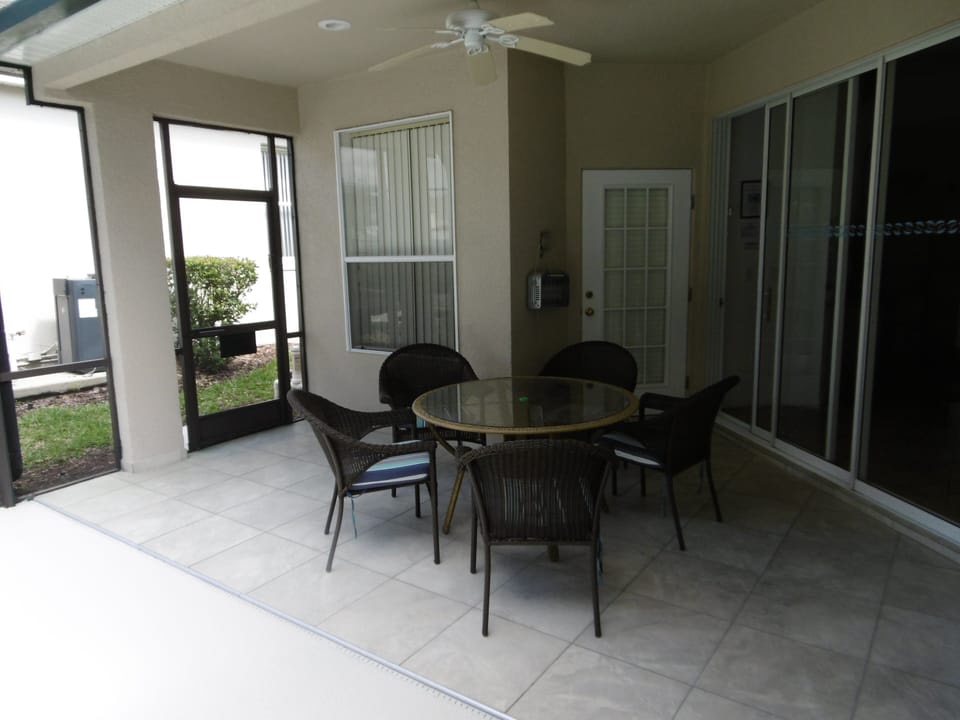 Tiled patio with ceiling fan, table an five chairs 