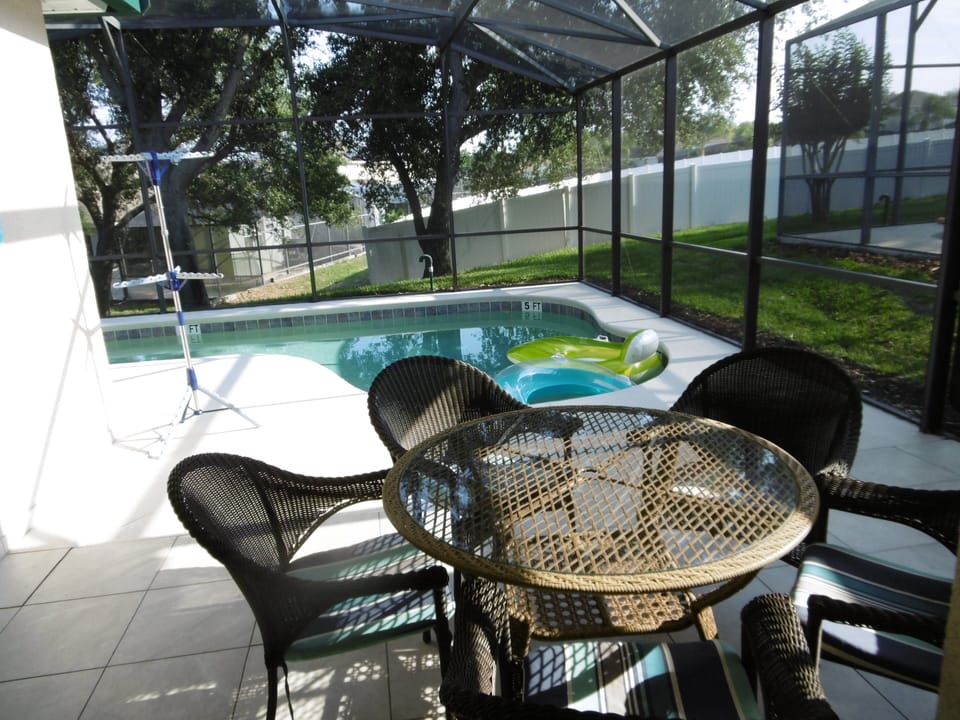 Tiled patio with ceiling fan, table an five chairs 