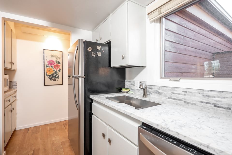 2nd photo of very fully stocked galley kitchen with quartz counters