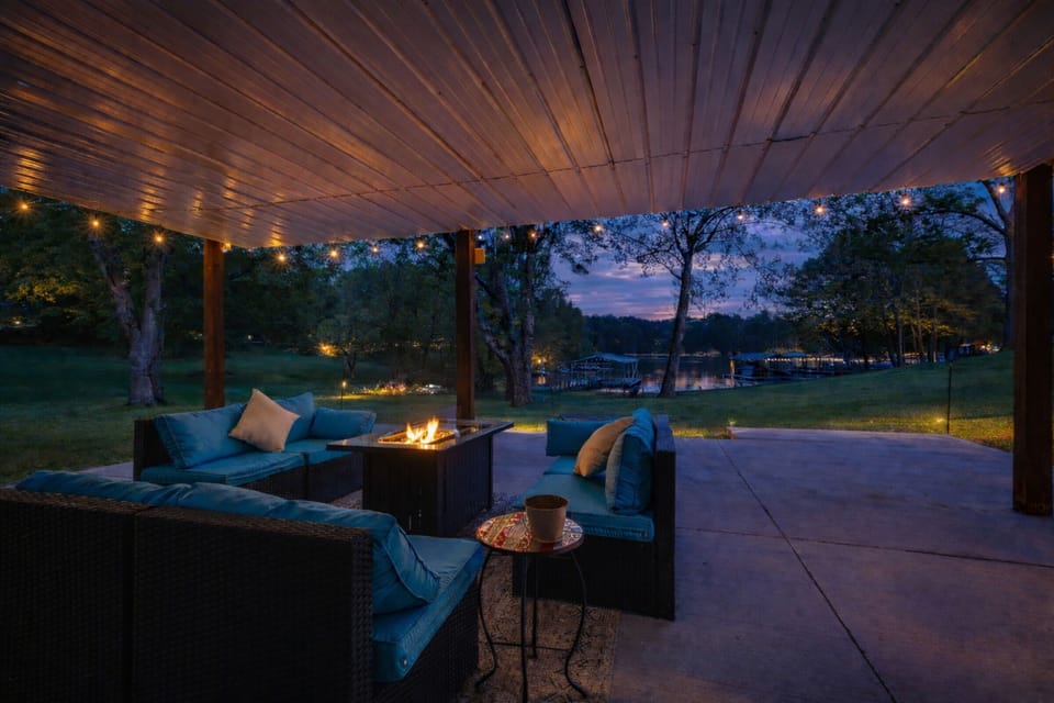 Lower patio evenings — lake views, string lights overhead, and the cozy glow of a propane fire table. All the ambiance of a fire, without the hassle.