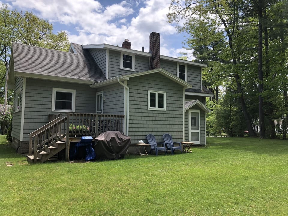 Back of house with deck and gas grill to cook outside in private tree lined yard