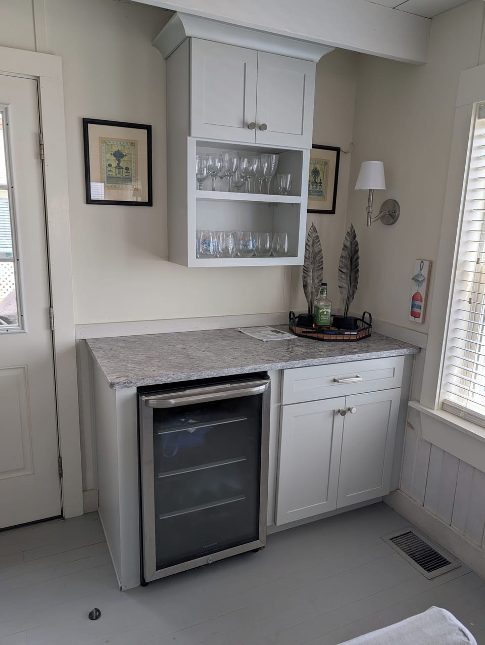 Dry bar in living room with granite counter, drink refrigerator