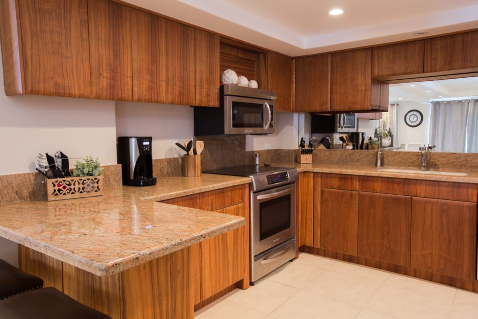 Kitchen with granite countertops, Koa cabinets and stainless appliances
