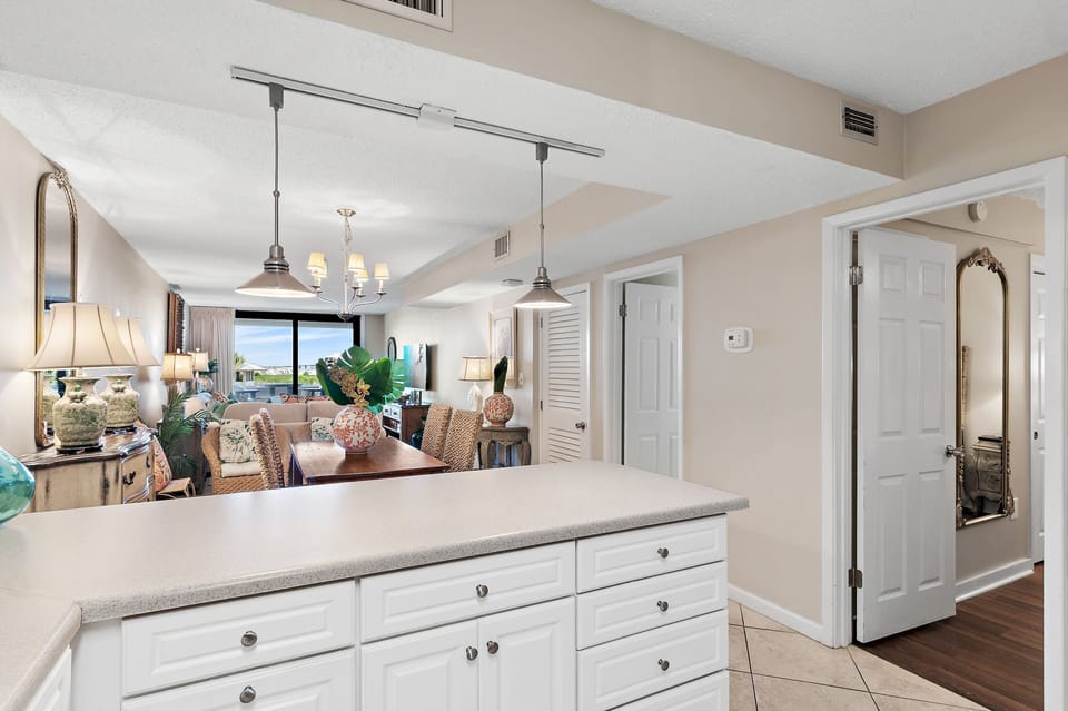 Step into your open kitchen and living space, where coastal breezes and ocean views await through expansive windows—your perfect retreat for cooking, dining, and unwinding together.