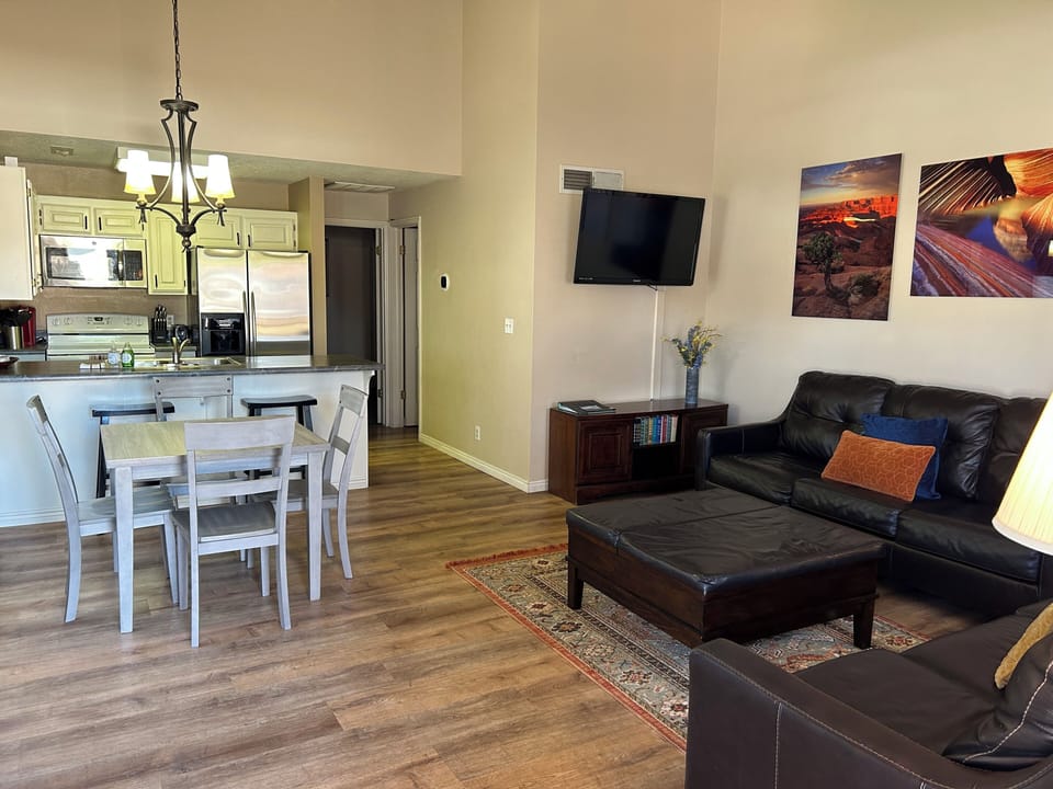 Large living room with vaulted ceiling, full size kitchen and dining table.