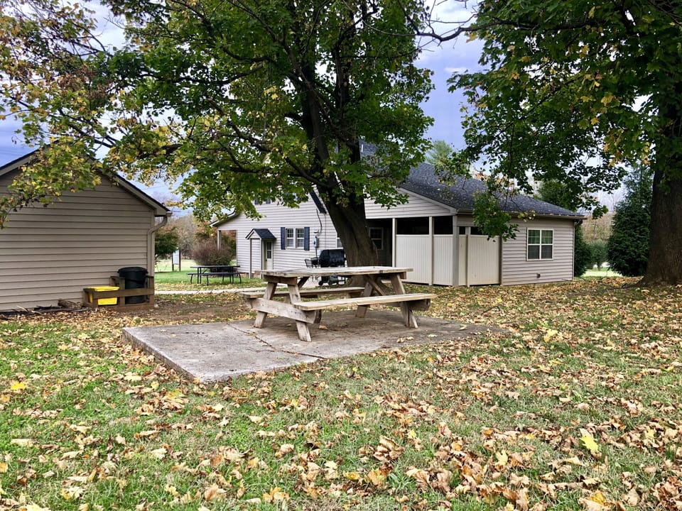 side porch and patio with picnic table, 4 top table, and grill
