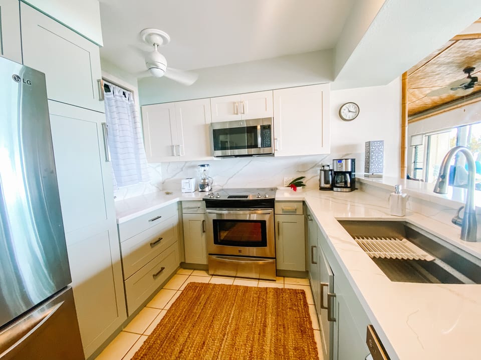 Fresh white quartz invites you to make meals in this full kitchen. 