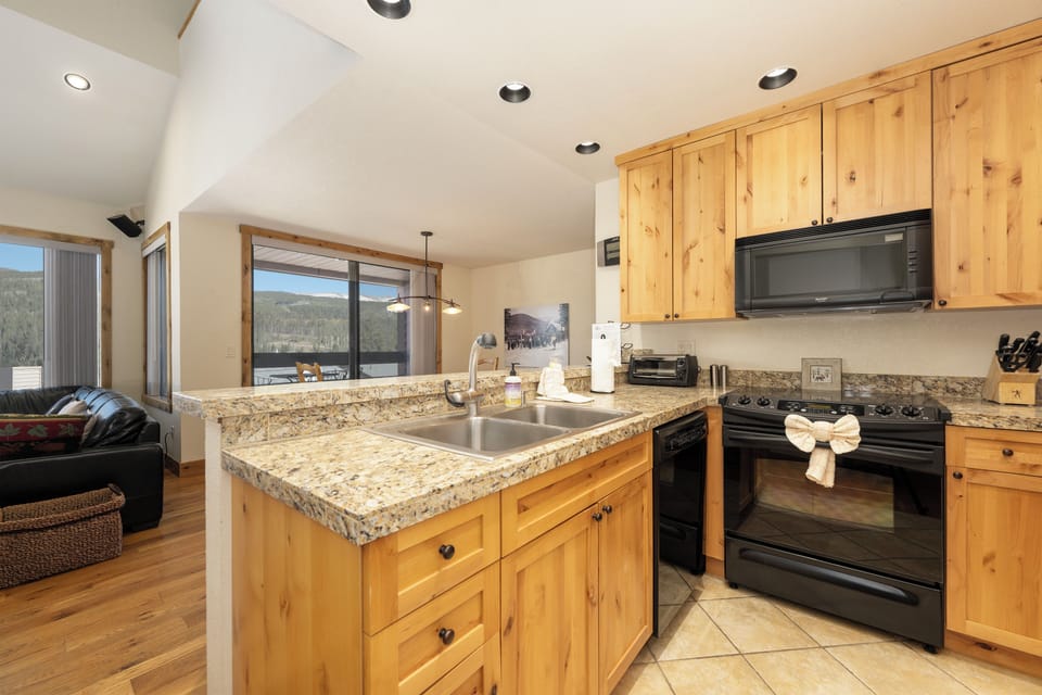 Cook with mountain views from your granite kitchen island, where warm wood cabinets and modern appliances create the perfect space for preparing meals.