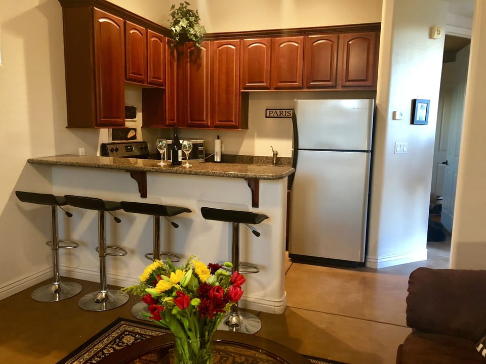 full kitchen with stove, microwave and fridge.
