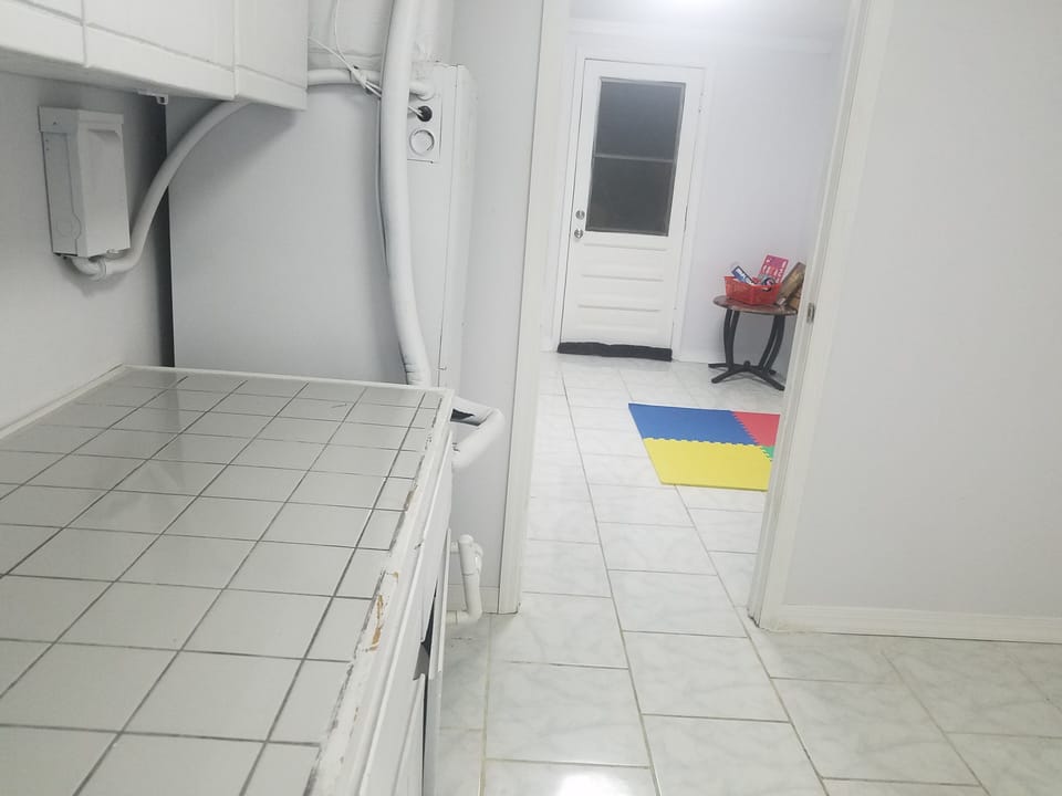 Laundry room on the main level past the kitchen with a large folding counter  