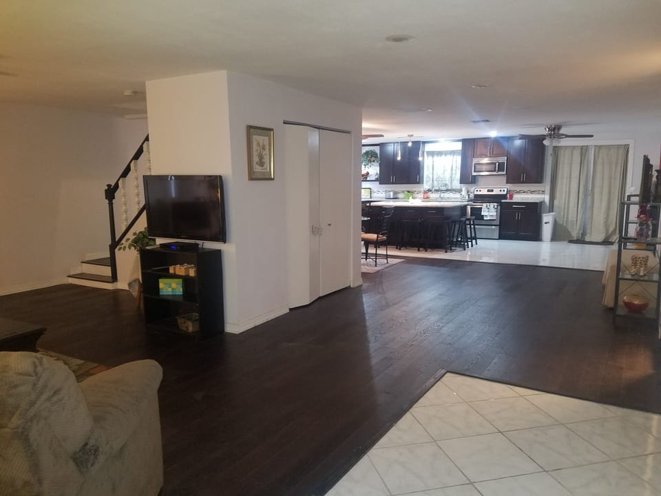 View from front door.  Hard wood flooring. Shows steps to upstairs on the Left