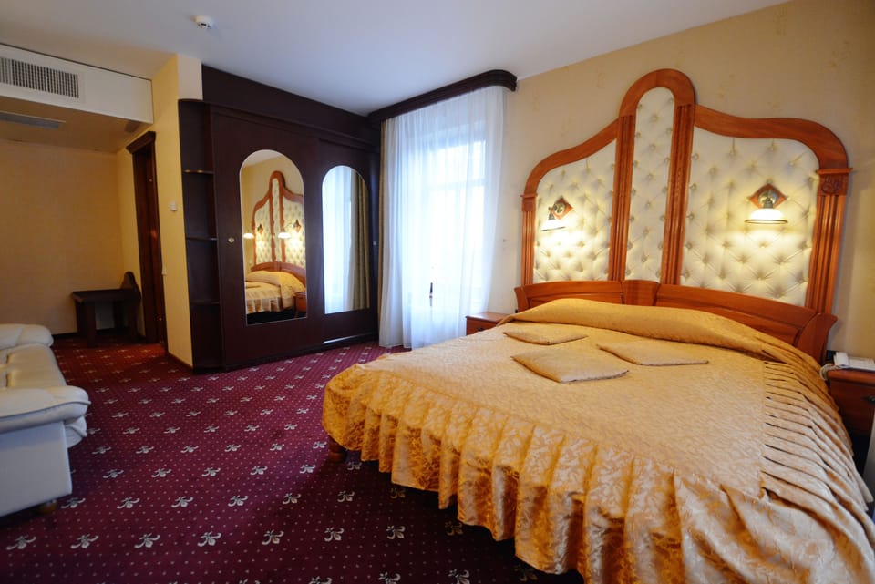Deluxe Room | Minibar, in-room safe, desk, iron/ironing board