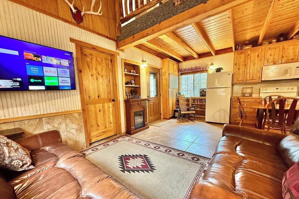Cozy living & full kitchen with smart TV and comfy leather sofas, perfect for relaxing after a day of adventure at HappyOur Ranch.